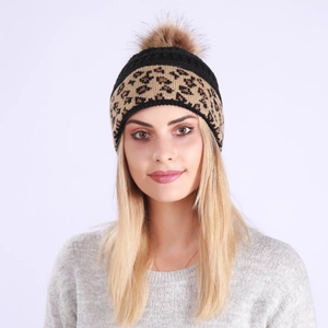 Detailed close-up of a chunky knit beanie featuring leopard print and a large faux fur pom