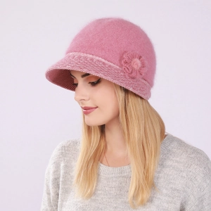 Detail of pink knit cloche hat showing plush rabbit fur texture and floral crochet accent
