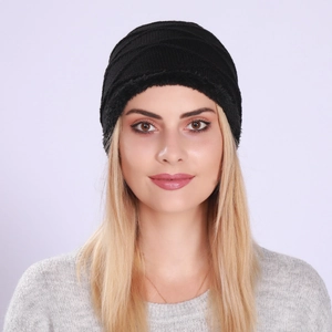Close-up of black cable-knit beanie with warm fleece lining and textured wave pattern
