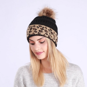 Detailed shot of leopard pattern knit beanie with fluffy brown faux fur pom pom top