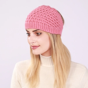 Gros plan détaillé du bandeau en tricot rose avec des motifs de fleurs ajourés