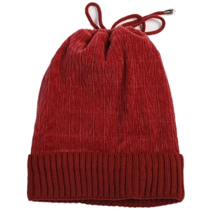 Close-up of deep red knitted beanie with adjustable drawstring and soft velvet texture