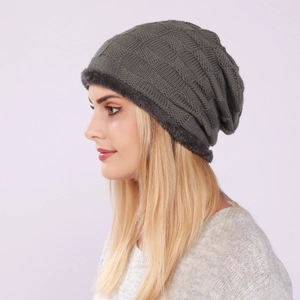 Detail of dark grey-green knit beanie with warm grey faux fur lining and checkered pattern
