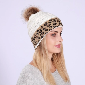 Detail of cable knit winter hat with brown pom-pom and leopard print cuff on model
