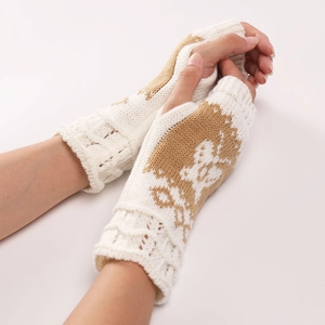 Dettaglio di guanti senza dita in maglia beige con motivi a renna e polsini a coste fini