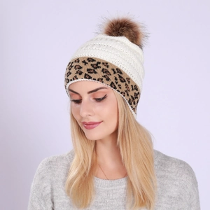 Detail of white and leopard print knit beanie with a brown faux fur pom-pom on top