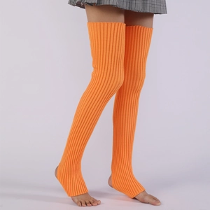 Detail of bright orange stirrup knit leg warmers with vertical ribbed texture for yoga