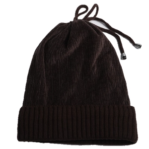 Detail of dark brown velvet beanie with drawstring and metallic tips on white background