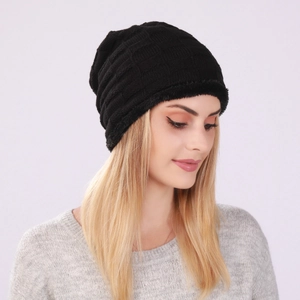 Detail of black knit beanie featuring plush fleece lining and textured checker pattern
