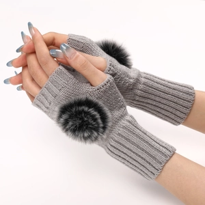 Détail de gants en maille grise sans doigts avec pompons en fausse fourrure noire douce