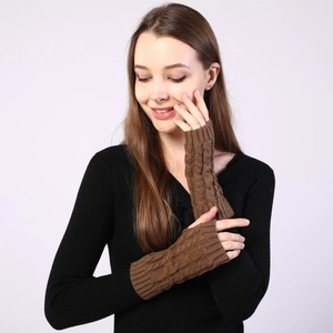 Close-up of brown cable-knit fingerless gloves showing thick texture and wool material