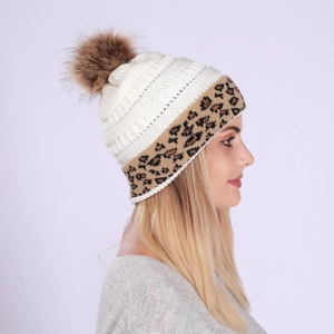 Detail of knitted beanie with leopard print rolled edge and fluffy faux fur pom-pom topper