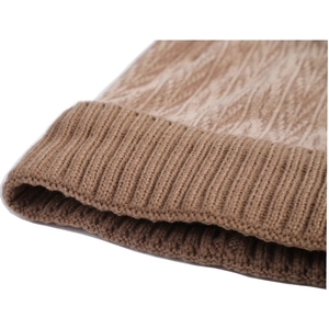 Detailed macro view of the thick cable knit pattern and ribbed cuff on a brown winter hat