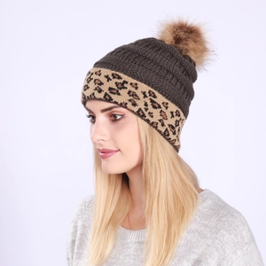 Detail of grey cable knit winter beanie with leopard print cuff and large faux fur pompom