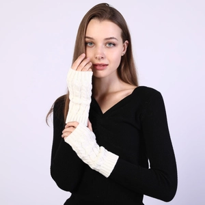 Detailed cable knit texture of beige fingerless arm warmers for cold weather