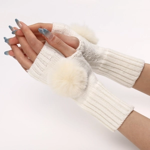 Détail de mitaines en maille blanche ornées d'un pompon en peluche doux et élégant