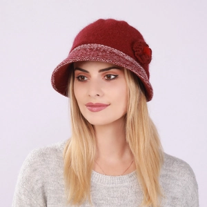 Detail of burgundy knitted bucket hat featuring a decorative flower and wool texture