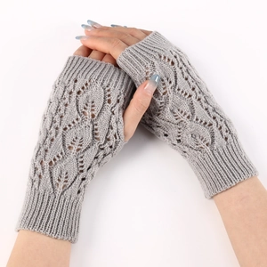 Detail of grey knitted fingerless glove featuring leaf cutout pattern and thumb hole design