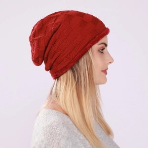 Detail of red checkered knit beanie with soft faux fur trim for winter warmth