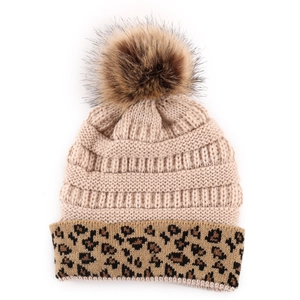 Close-up of beige knitted beanie featuring leopard print cuff and large faux fur pompom