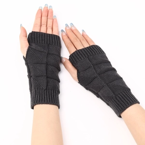 Detailed close-up of dark grey knitted fingerless gloves with wave diamond patterns