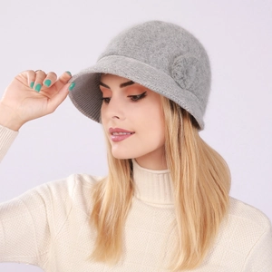 Detailed view of a grey plush knitted bucket hat with woven flower and warm lining
