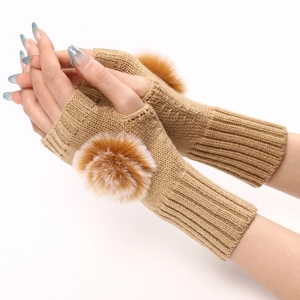Détail de mitaines en tricot kaki avec décoration de pompon en fausse fourrure