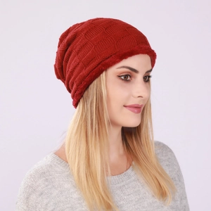 Detail of red checkered knit beanie with plush faux fur trim for winter warmth