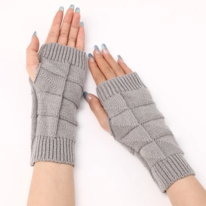 Detailed view of grey knitted fingerless gloves featuring chunky square textured pattern