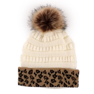 Close-up of knit winter beanie with leopard print cuff and fluffy faux fur pompom