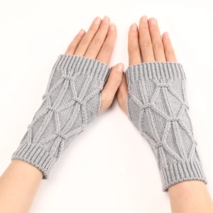 Détail de mitaines en tricot gris montrant le motif de losanges et les bords côtelés