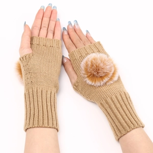 Gros plan de mitaines en tricot camel avec des détails décoratifs de pompons doux