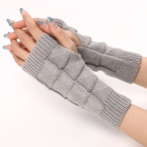 Detailed close-up of grey knitted fingerless gloves showing 3D checkered texture and rib cuff