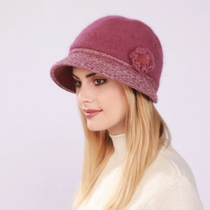 Detail of pink knitted cloche hat featuring a 3D floral accent and soft wool texture