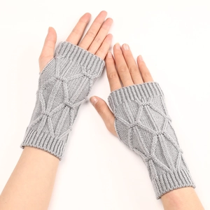 Détail macro de mitaines en tricot gris clair avec un motif de losanges texturés