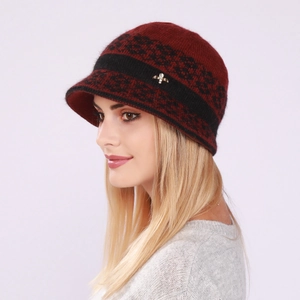 Close-up of burgundy knitted winter hat with floral pattern and silver insect pin