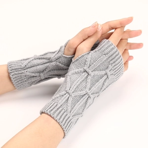 Détail de mitaines en tricot gris clair avec un motif de losanges texturés