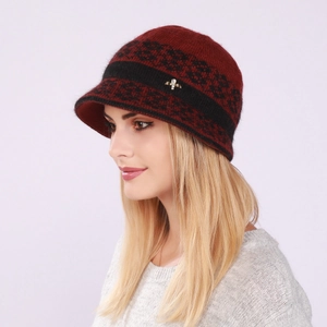 Detail of burgundy knitted visor hat featuring jacquard pattern and golden metal accent