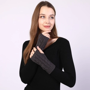 Detail of dark grey cable knit fingerless gloves showing rib cuffs and thick texture
