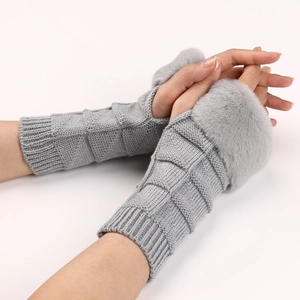 Close-up of gray knit fingerless gloves with fluffy faux fur trim and textured pattern