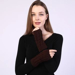 Detail of dark brown cable-knit fingerless gloves showing warm winter texture and design