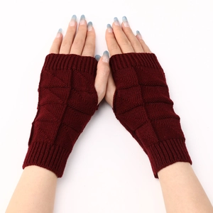 Detail of burgundy knitted fingerless gloves with a decorative diamond lattice texture