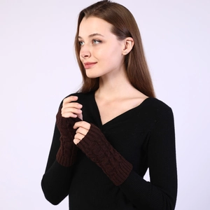 Close-up of cable knit fingerless gloves in dark brown wool showing texture and fit