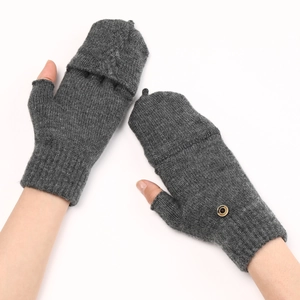 Détail du tricot torsadé gris sur gants sans doigts avec rabat et bouton décoratif