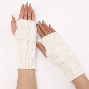 Detail of white knit fingerless gloves with geometric texture and ribbed cuffs