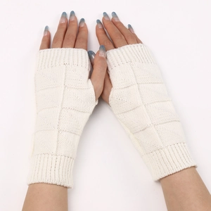 Detail of cream white knitted fingerless gloves showing the thick geometric texture