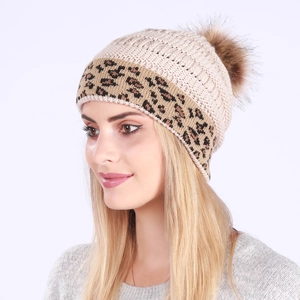 Chunky beige knit winter hat with leopard print cuff and large brown faux fur pom pom