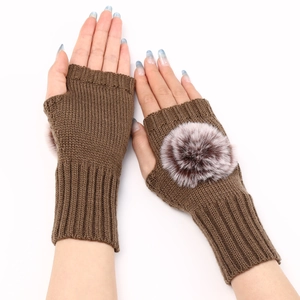 Détail de gants en tricot marron sans doigts avec pompons et poignets côtelés fins