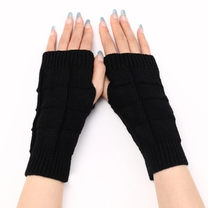 Detail of black knitted fingerless gloves showing textured checkered weave and ribbed cuffs