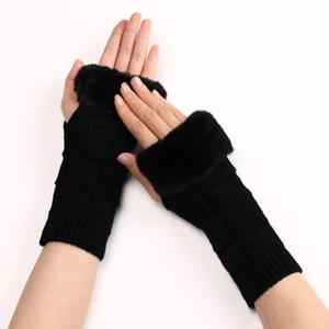 Close-up of black knitted fingerless gloves featuring faux fur trim and textured patterns
